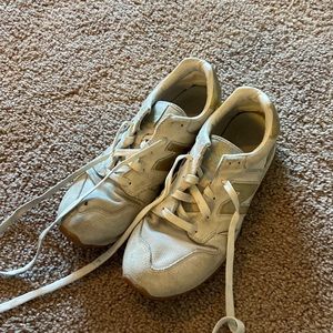 Well worn Gold J. crew new balance sneakers. Hold on top of right shoe.